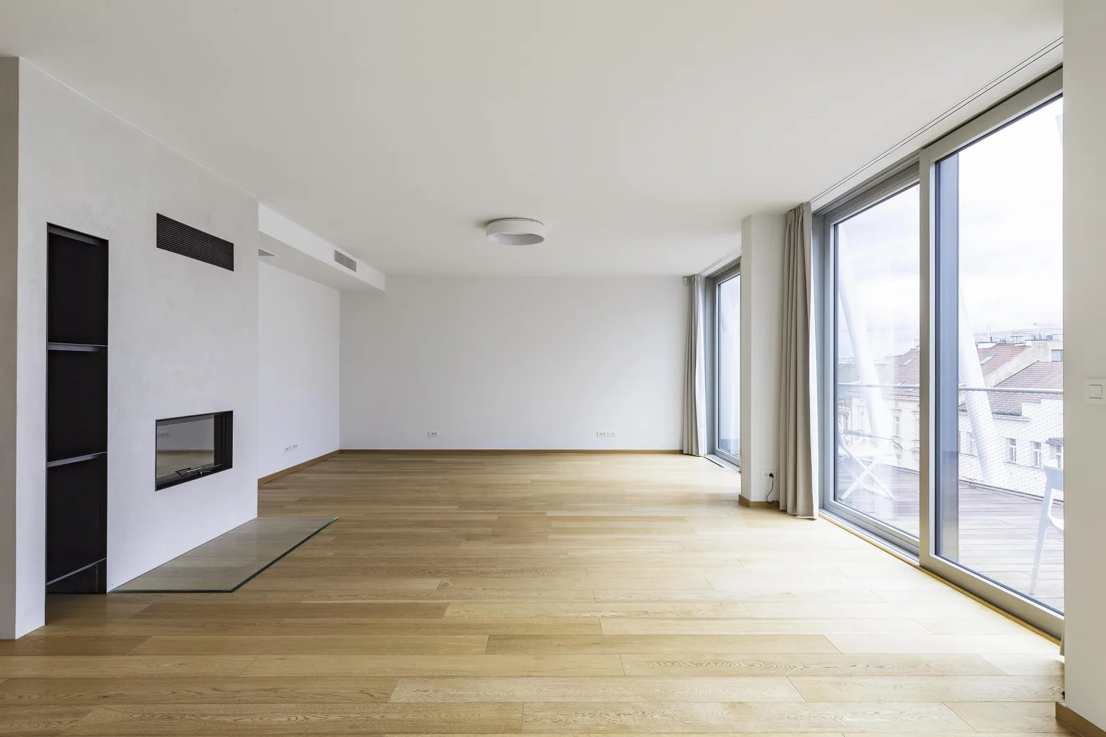 A bright Ellipsis apartment living room with fireplace and floor-to-ceiling windows